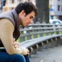  A young man sitting on a park bench.